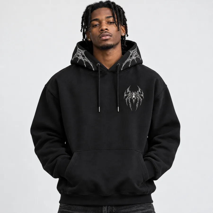 Black American male model wearing the black Chrome Crawler Hoodie with chrome spider chest graphic and hood web accents