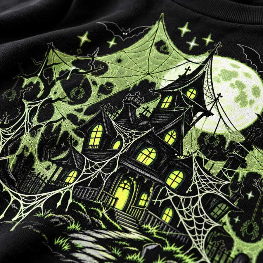Close-up of Glow Haunted Web print showing crooked haunted house, pale green webs, spiders, bats and moon