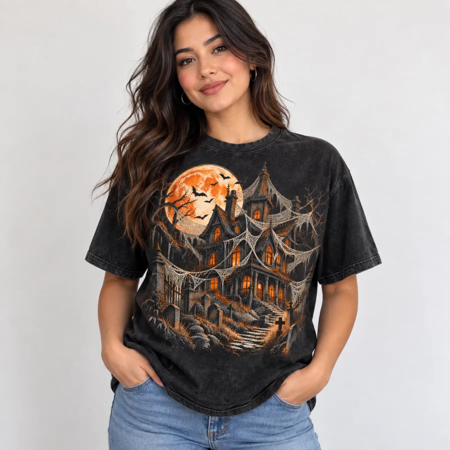 Woman wearing washed black Haunted House Spider Shirt with distressed cream, orange and gray haunted mansion artwork
