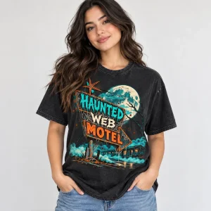 Model wearing washed black Haunted Web Motel unisex tee with moonlit spider and roadside motel sign graphic