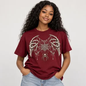 Model wearing burgundy Skeleton Hand Web unisex tee with skeletal hands stretching a detailed spider web across the chest