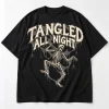 Front flat lay of black oversized skeleton spider shirt with TANGLED ALL NIGHT dancing skeleton and web print