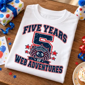 Folded White Kids Spider Balloon Parade spider balloon birthday shirt on wooden table with colorful fifth birthday artwork visible