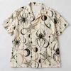 Front flat lay of ivory Web Geometry Camp geometric spider button up shirt
