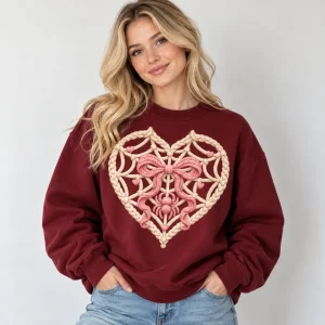 Woman wearing burgundy Web Heart Knit crewneck with a pleated skirt