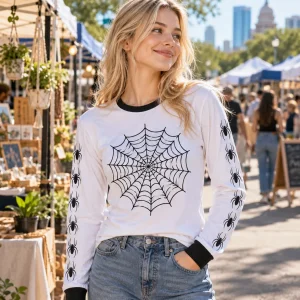 Lifestyle view of a woman wearing the Webline Ringer spider web ringer shirt at a street market